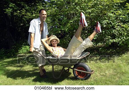 man pushing his woman in a wheelbarrow View Large Photo Image Stock Image - man pushing his woman in a wheelbarrow. Fotosearch
