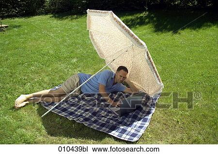 man with his laptop computer under a sunshade View Large Photo Image Stock Image - man with his laptop computer under a sunshade. Fotosearch