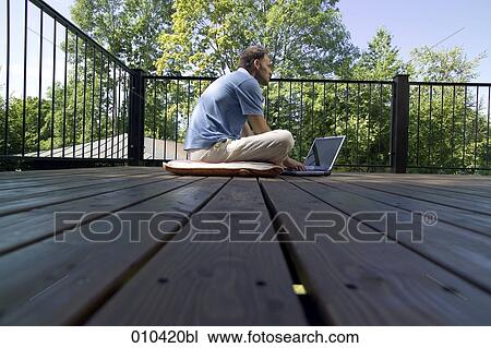 man working with laptop on his veranda View Large Photo Image Stock Image - man working with laptop on his veranda. Fotosearch