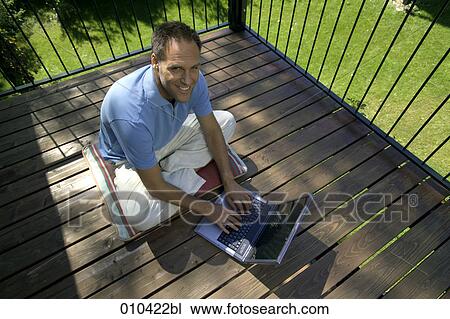 man working with laptop on his veranda View Large Photo Image Stock Image - man working with laptop on his veranda. Fotosearch