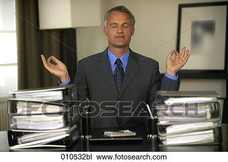 mature businessman in meditation pose sitting behind piles of folders View Large Photo Image Stock Image - mature businessman in meditation pose sitting behind piles of folders. Fotosearch