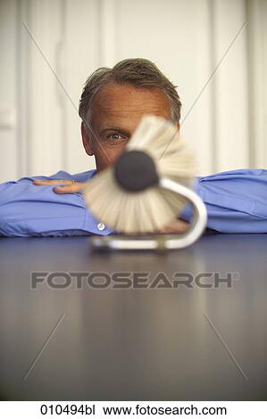 Stock Image - mature businessman looking at rolodex. Fotosearch