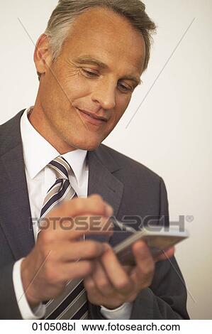 mature businessman making notes on electronic organizer View Large Photo Image Stock Image - mature businessman making notes on electronic organizer. Fotosearch