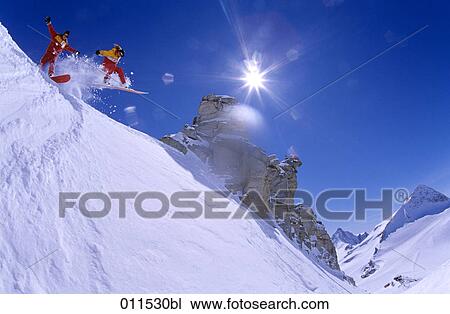 people on snowboards jumping over mountain cliff View Large Photo Image Stock Image - people on snowboards jumping over mountain cliff. Fotosearch