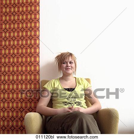 Portrait of blonde girl sitting in arm chair View Large Photo Image Stock Image - Portrait of blonde girl sitting in arm chair. Fotosearch