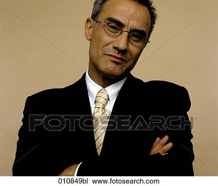 Stock Image - Portrait of businessman with arms crossed. Fotosearch