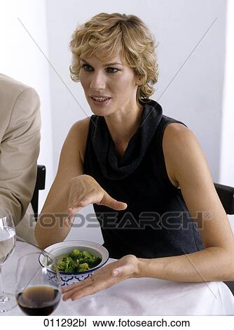 Stock Image - portrait of businesswoman making an explanation during lunch. Fotosearch