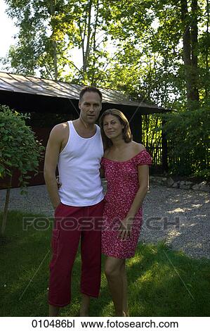 portrait of couple in garden standing in front of weekend house View Large Photo Image Stock Image - portrait of couple in garden standing in front of weekend house . Fotosearch