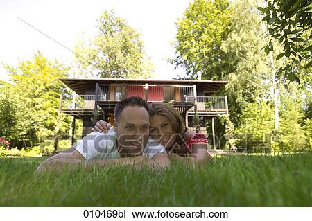 Stock Image - portrait of couple lying in the grass. Fotosearch