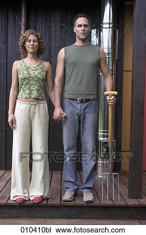 Stock Image - portrait of couple wearing casual with pitch-fork. Fotosearch