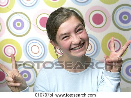 portrait of grinning girl doing the victory-sign View Large Photo Image Stock Image - portrait of grinning girl doing the victory-sign. Fotosearch