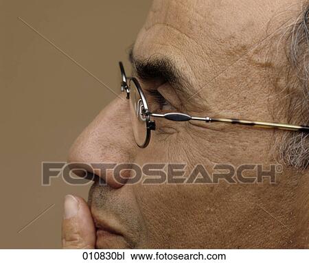 Portrait of mature man wearing glasses, putting finger on his mouth View Large Photo Image Stock Image - Portrait of mature man wearing glasses, putting finger on his mouth. Fotosearch