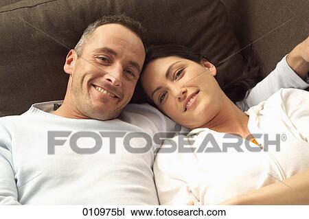 Portrait of smiling couple on sofa View Large Photo Image Stock Image - Portrait of smiling couple on sofa. Fotosearch