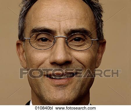 Stock Image - Portrait of smiling man wearing glasses. Fotosearch