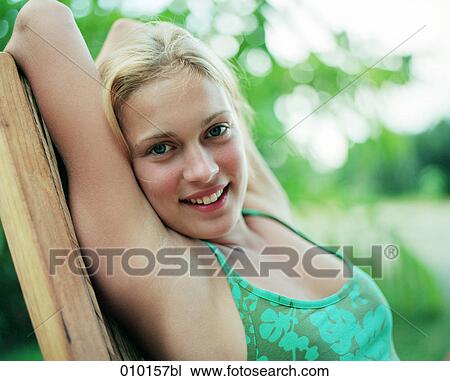 Stock Image - portrait of smiling teenage woman in chair. Fotosearch
