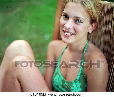 Stock Image - portrait of smiling teenage woman (16-19 years) in chair. Fotosearch