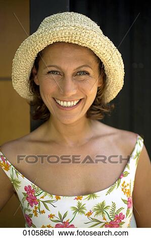 portrait of smiling woman in flowery dress wearing a straw hat View Large Photo Image Stock Image - portrait of smiling woman in flowery dress wearing a straw hat. Fotosearch