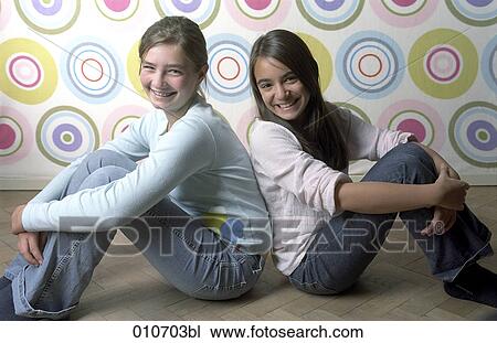 portrait of two smiling girls sitting back to back View Large Photo Image Stock Image - portrait of two smiling girls sitting back to back. Fotosearch