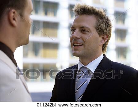 Stock Image - portrait of young businessman during a conversation. Fotosearch