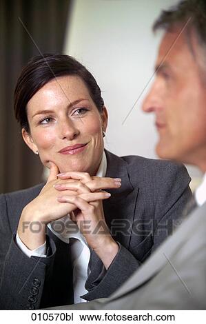 Stock Image - portrait of young businesswoman looking at colleague. Fotosearch