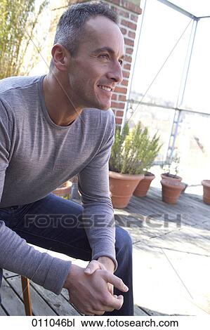 Portrait of young man sitting on a terrace View Large Photo Image Stock Image - Portrait of young man sitting on a terrace. Fotosearch