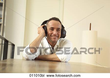 Stock Image - Portrait of young man with headphones on. Fotosearch