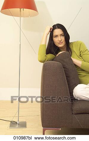 Portrait of young woman on her sofa in the living room View Large Photo Image Stock Image - Portrait of young woman on her sofa in the living room. Fotosearch