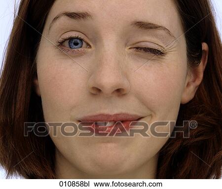 Stock Image - Portrait of young woman winking. Fotosearch