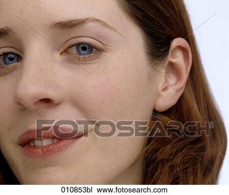 Stock Image - Portrait of young woman with blue eyes and red hair. Fotosearch