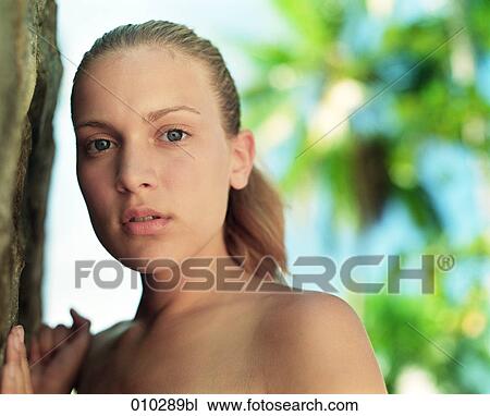 Stock Image - potrait of young woman (16-19 years) leaning on tree. Fotosearch