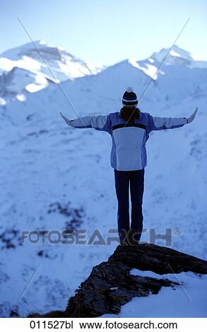 Stock Image - rear view of woman standing on mountain top. Fotosearch