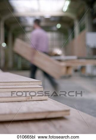 Stock Image - several wooden planks lying on a table in a joinery. Fotosearch