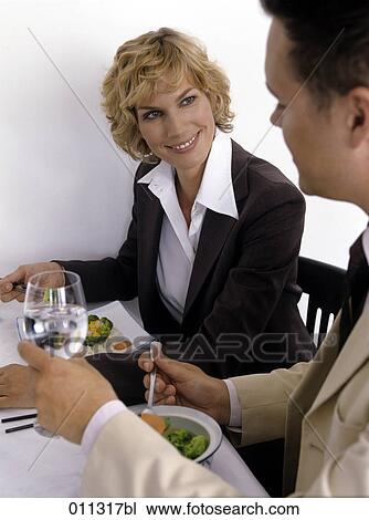 Stock Image - smiling businesswoman at lunch with colleague. Fotosearch