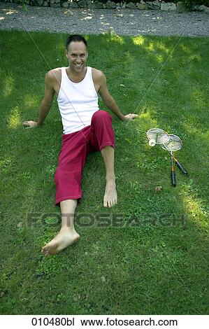 smiling man sitting on grass in garden View Large Photo Image Stock Image - smiling man sitting on grass in garden. Fotosearch