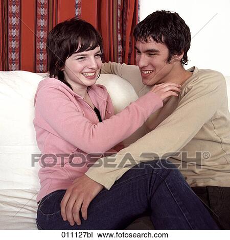 Smiling teenage couple sitting together View Large Photo Image Stock Image - Smiling teenage couple sitting together. Fotosearch