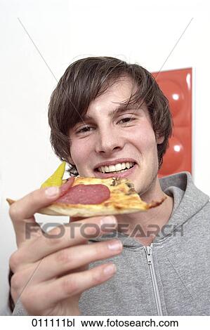 Teenage boy eating slice of pizza View Large Photo Image Stock Image - Teenage boy eating slice of pizza. Fotosearch