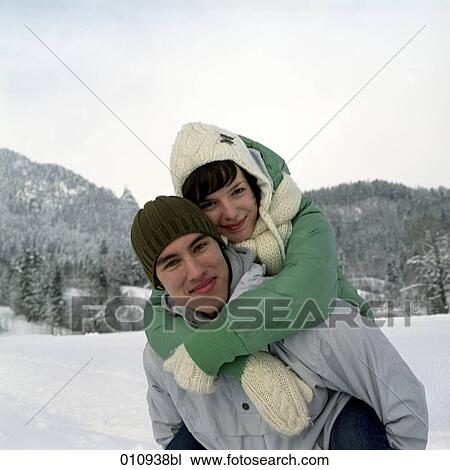 Stock Image - teenage couple enjoying a day out in the snow. Fotosearch