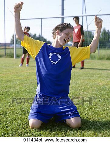 teenage football player kneeling in grass, celebrating win View Large Photo Image Stock Image - teenage football player kneeling in grass, celebrating win . Fotosearch