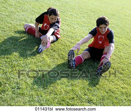 teenage football players stretching to warm up before football game View Large Photo Image Stock Image - teenage football players stretching to warm up before football game. Fotosearch