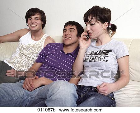 Teenage girl talking on mobile while sitting together with two friends View Large Photo Image Stock Image - Teenage girl talking on mobile while sitting together with two friends. Fotosearch