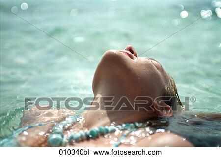 Stock Image - teenager (16-19 years) relaxing in the water. Fotosearch