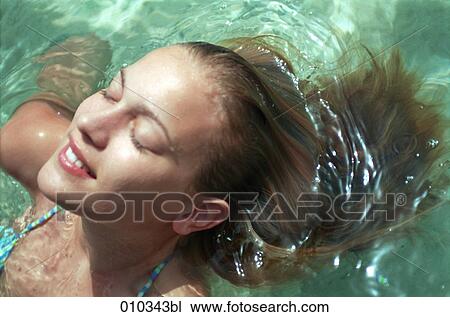 Stock Image - teenager (16-19 years) relaxing in the water. Fotosearch
