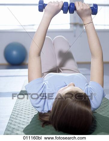 Teenager doing training with dumb bells in gym View Large Photo Image Stock Image - Teenager doing training with dumb bells in gym. Fotosearch