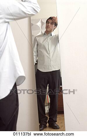 Teenager in front of the mirror adjusting his hair View Large Photo Image Stock Image - Teenager in front of the mirror adjusting his hair. Fotosearch