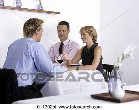 three businessmen sitting in a restaurant View Large Photo Image Stock Image - three businessmen sitting in a restaurant. Fotosearch