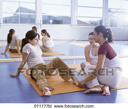 Stock Image - Three women taking a break from physical exercise. Fotosearch