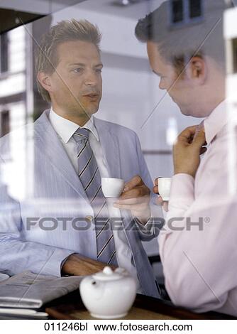 Stock Image - two businessmen having coffee together. Fotosearch