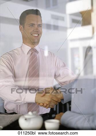 two businessmen shaking hands in a cafe View Large Photo Image Stock Image - two businessmen shaking hands in a cafe. Fotosearch