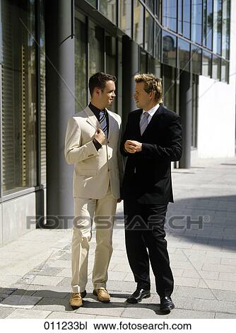 Stock Image - two businessmen talking outdoors. Fotosearch