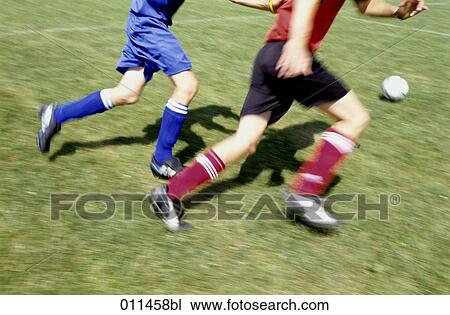 two football players running after the ball View Large Photo Image Stock Image - two football players running after the ball. Fotosearch